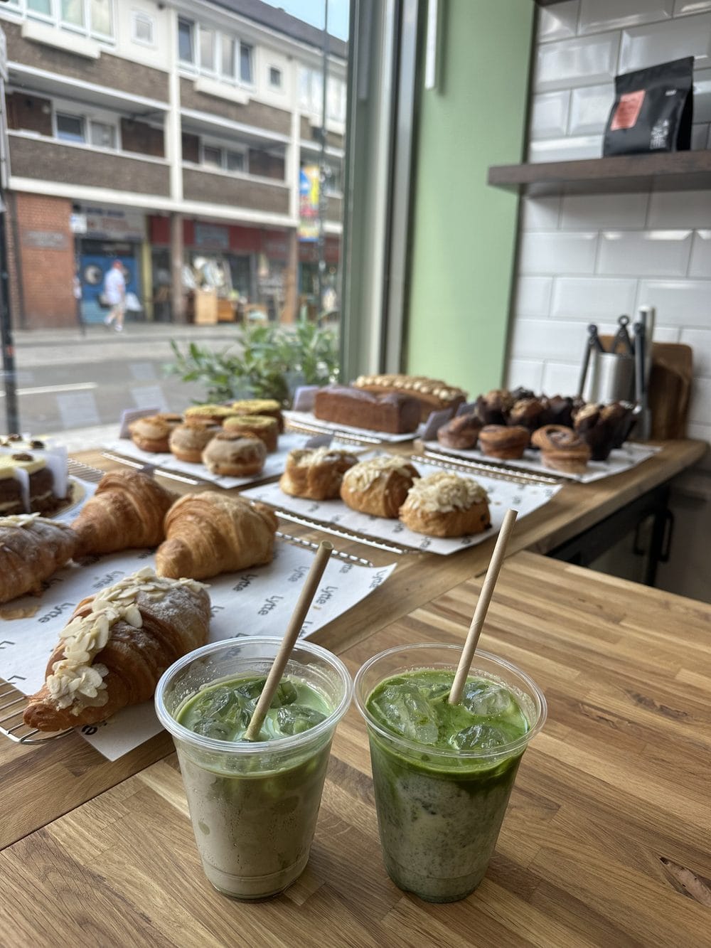 Iced matcha lattes on the wooden counter looking out to North End Road